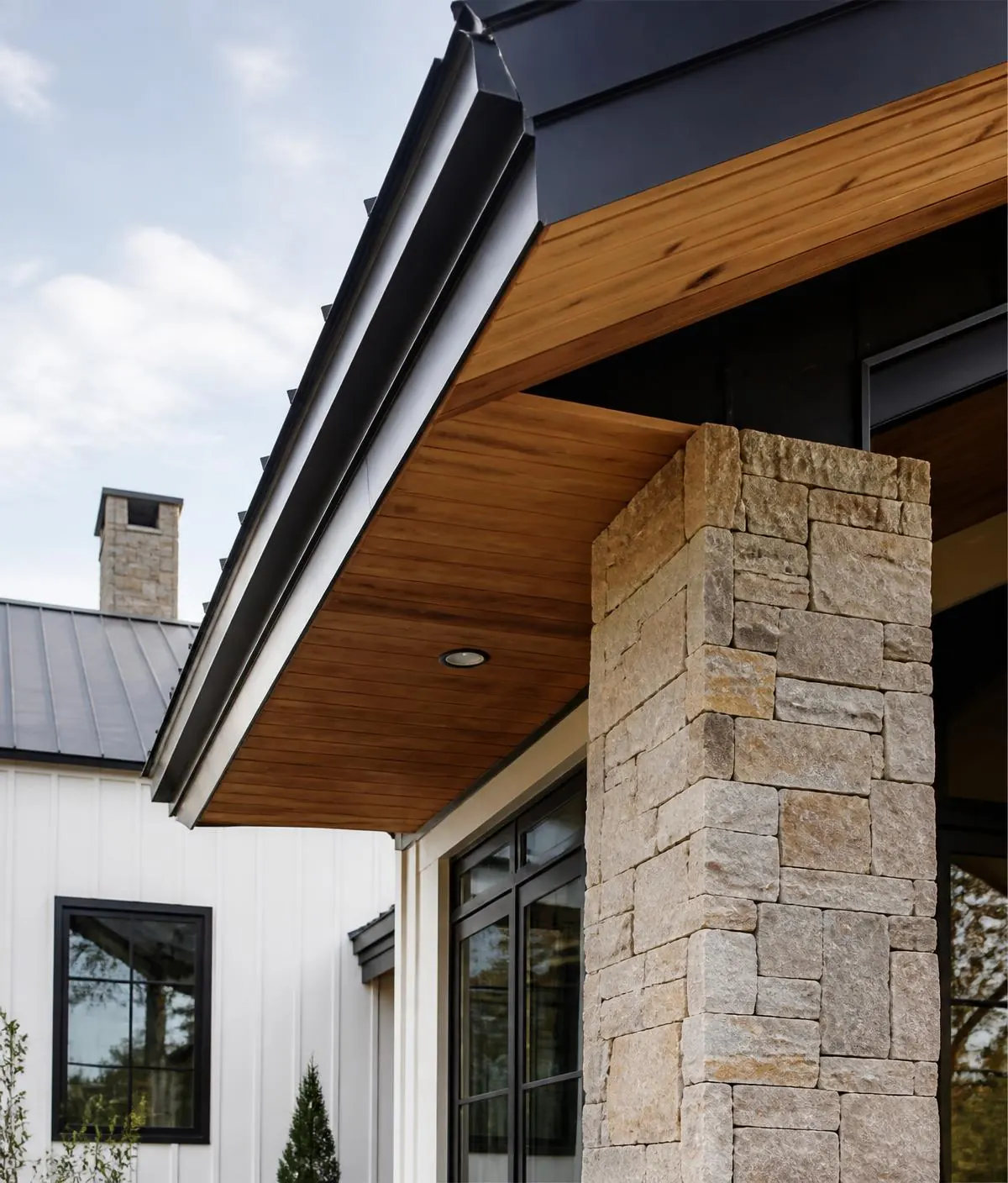 Exterior architectural detail of cedar soffit and stone column — placeholder imagery